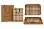 This gift packaging set featuring a brown paper shopping bag, a matching plaid shopping bag, and two plaid-lined gift boxes with gold-tone corner protectors, all on a white background.